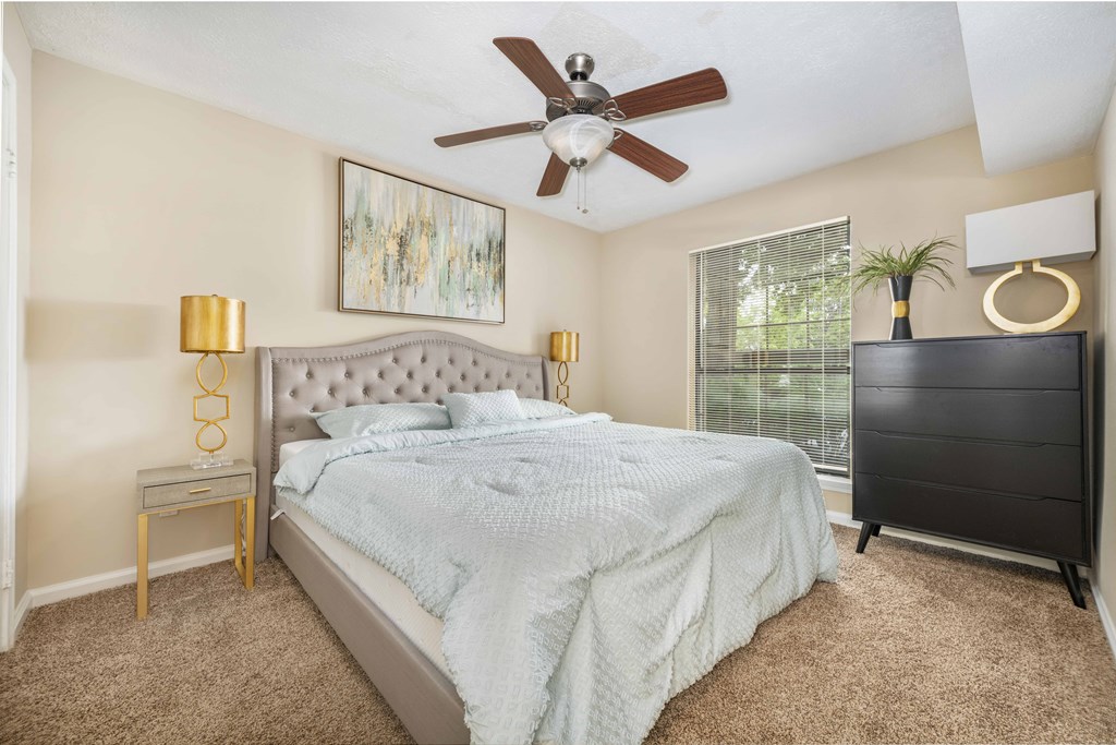 a bedroom with a bed and a ceiling fan