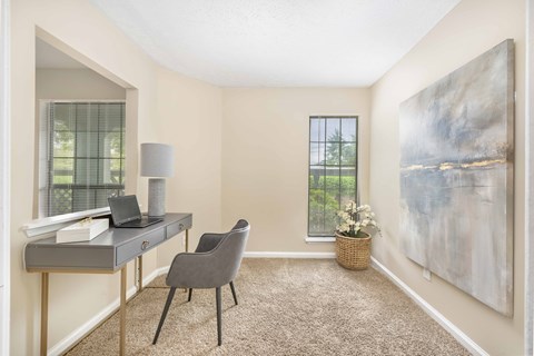 an office with a desk and a chair and a large window