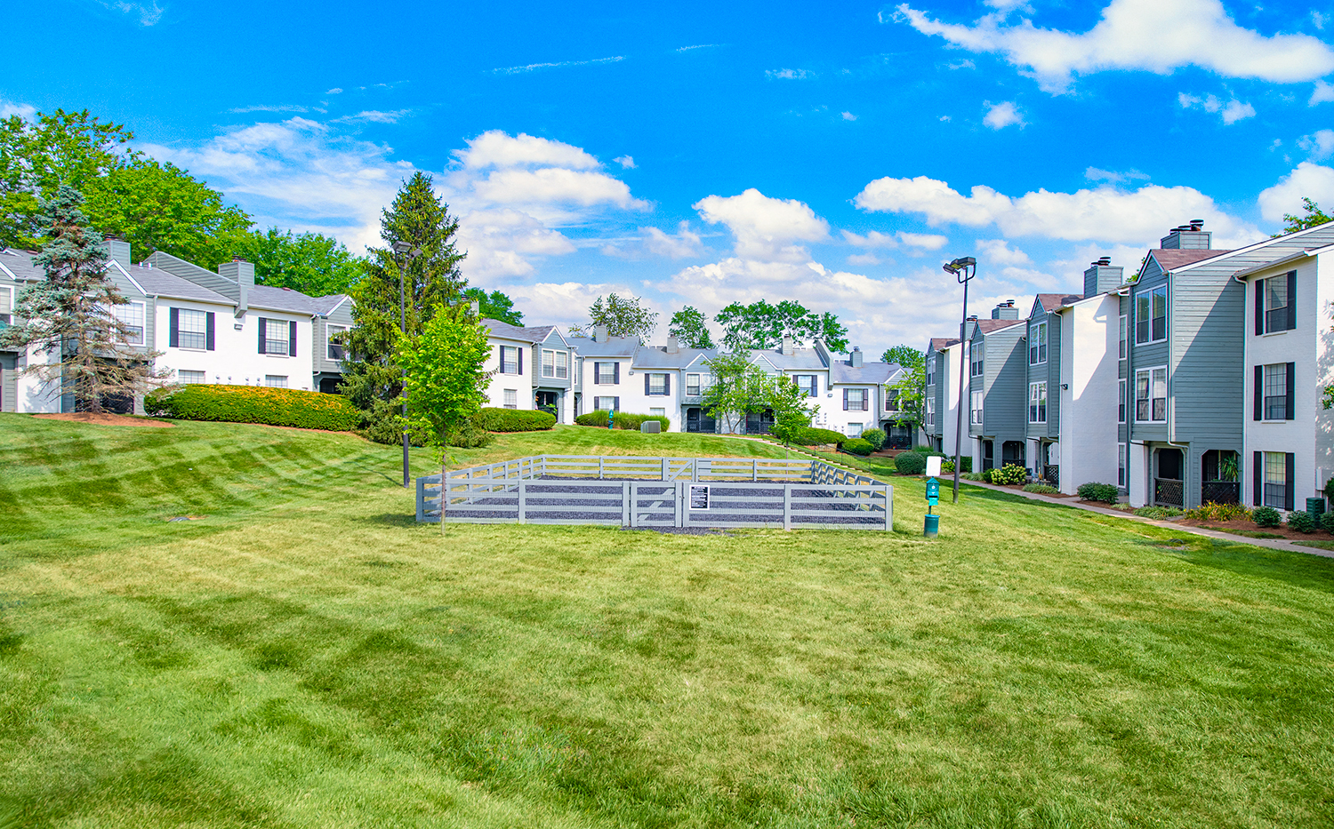 a park with a fence in front of some houses