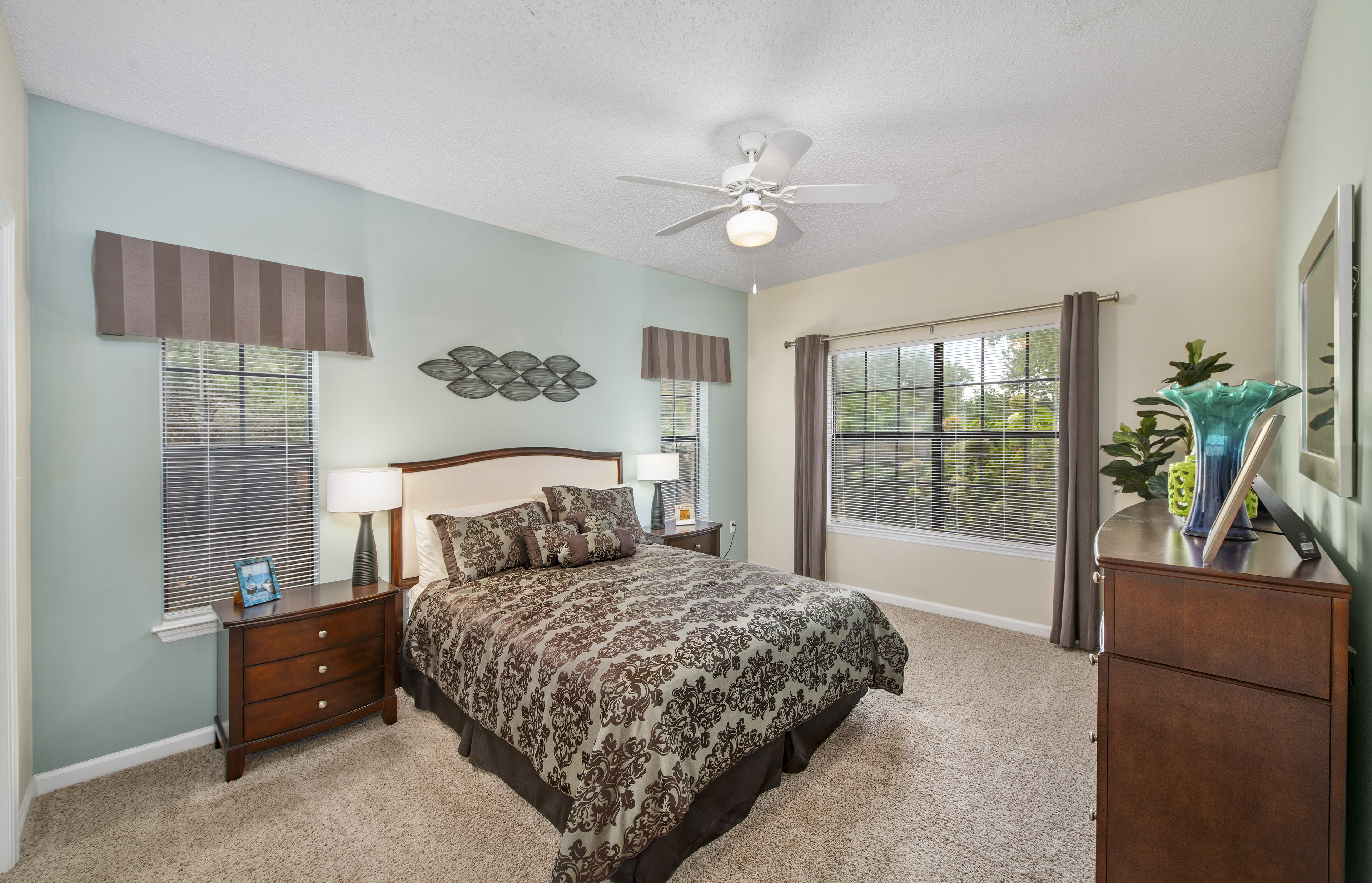 a bedroom with a bed and a ceiling fan