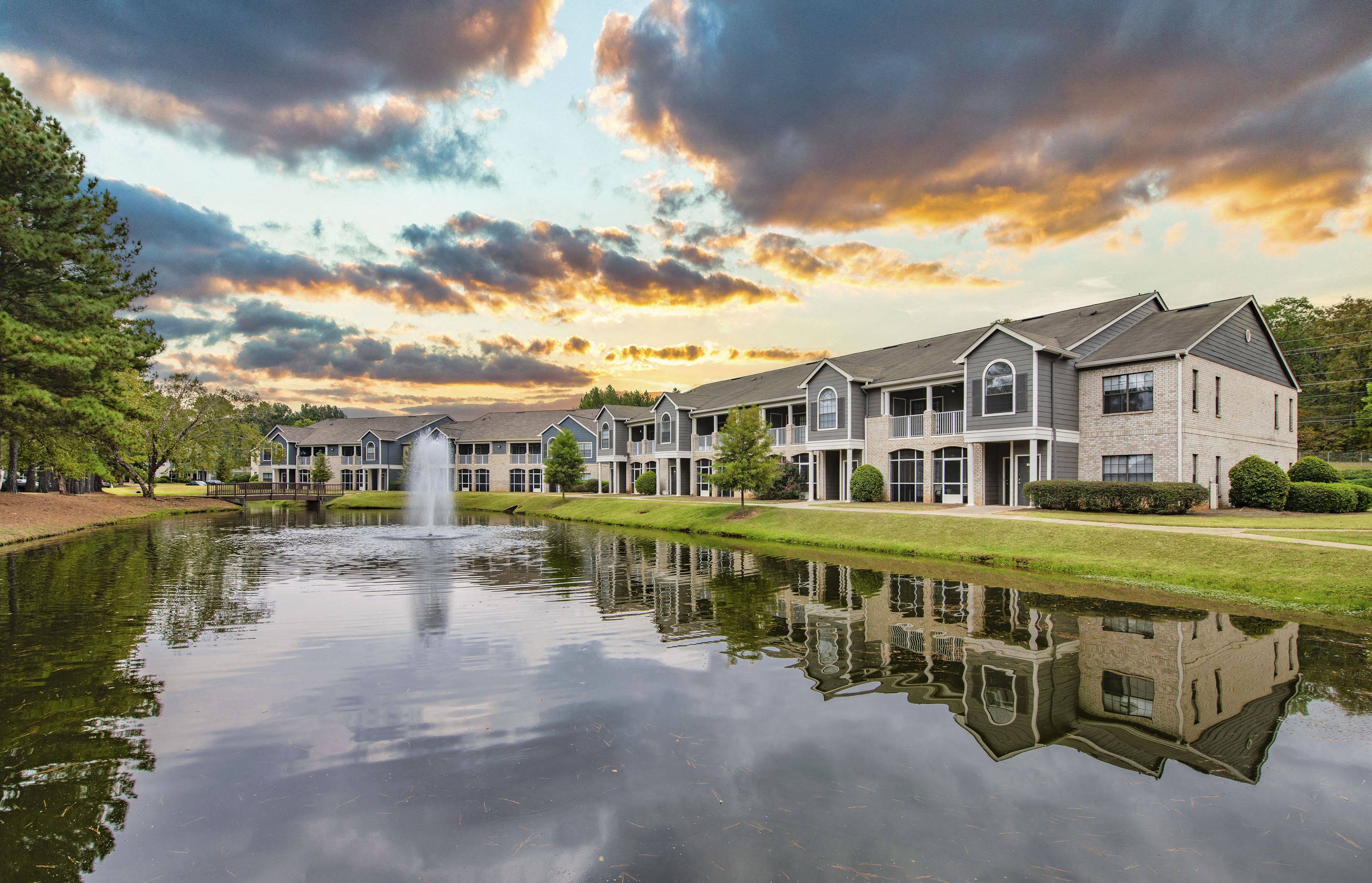 a pond with a fountain in front of a building