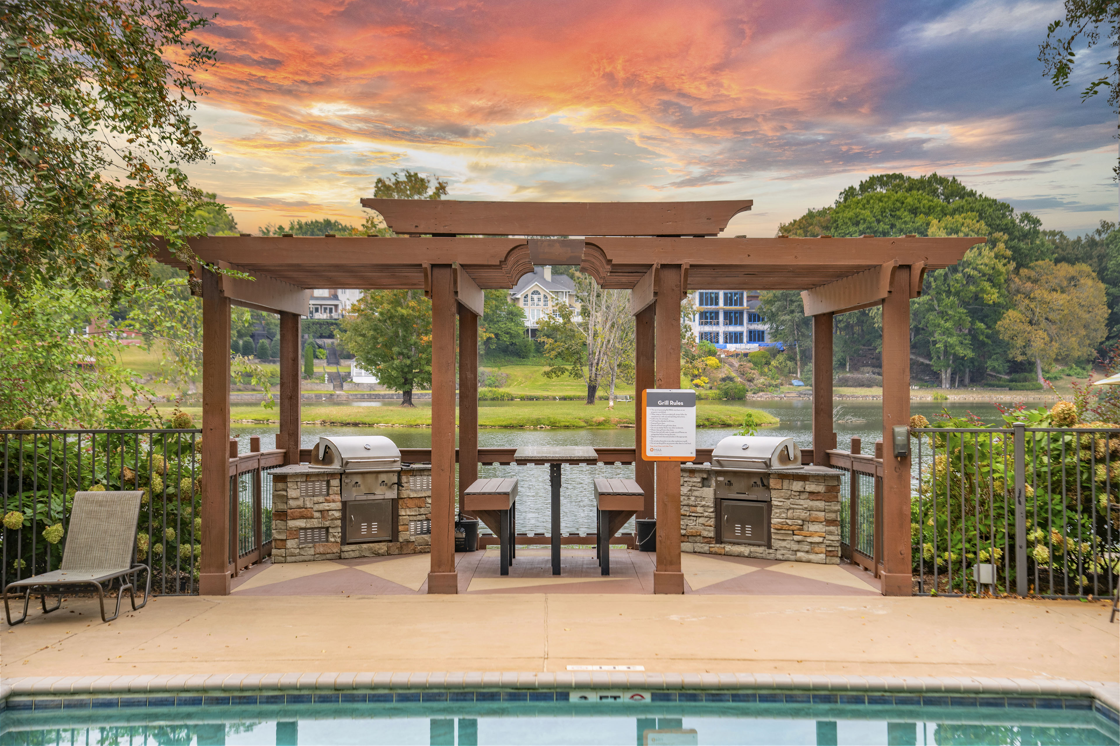a swimming pool with a wooden gazebo with a table and chairs