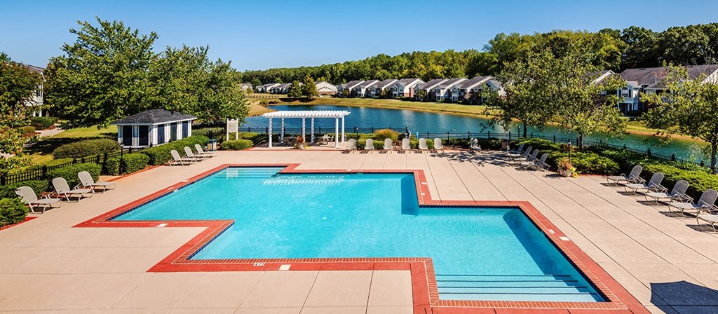an aerial view of a swimming pool with chairs around it and a resort style pool