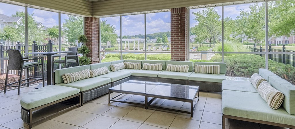 a living room with couches and a table in front of windows