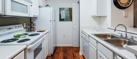 a kitchen with white cabinets and a sink and a refrigerator