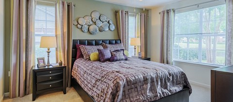a bedroom with a bed and two windows