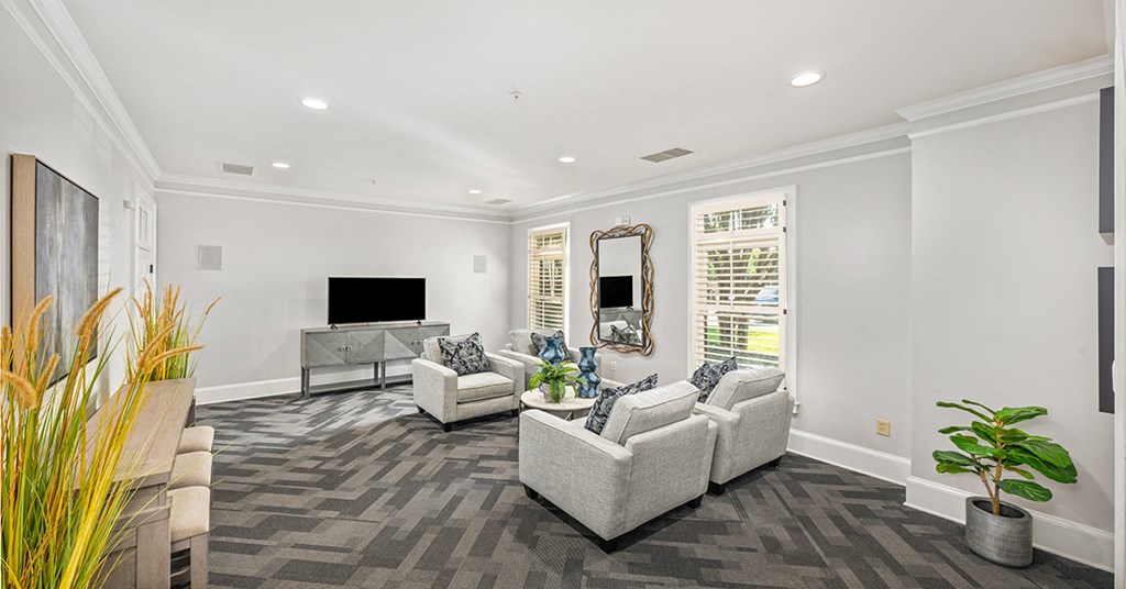 A living room with a grey carpet and white furniture.