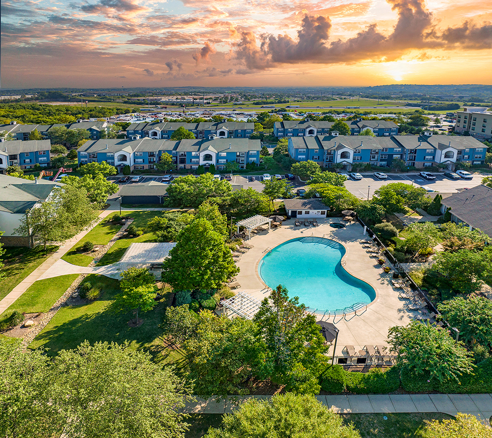 an aerial view of a swimming pool in a neighborhood with houses