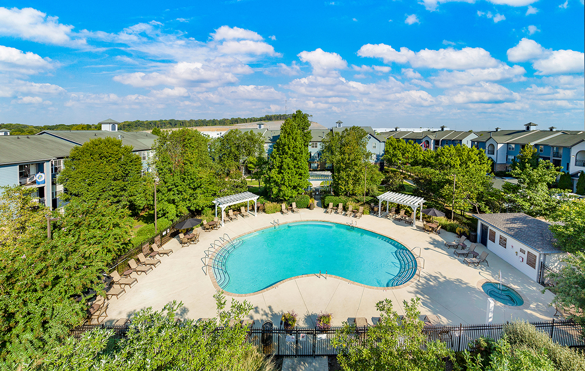 an aerial view of a swimming pool with trees and houses