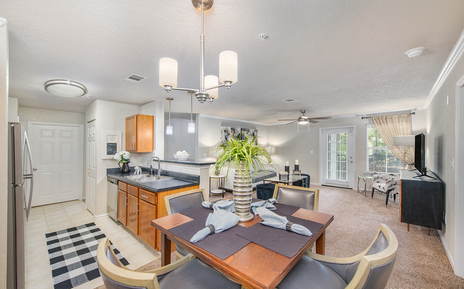 a living room with a dining room table and a kitchen
