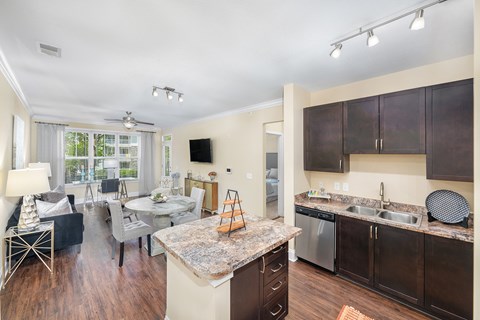 A kitchen with dark wood cabinets and a granite counter top.