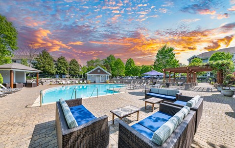 A sunny day at the poolside with two sunbeds and a swimming pool.