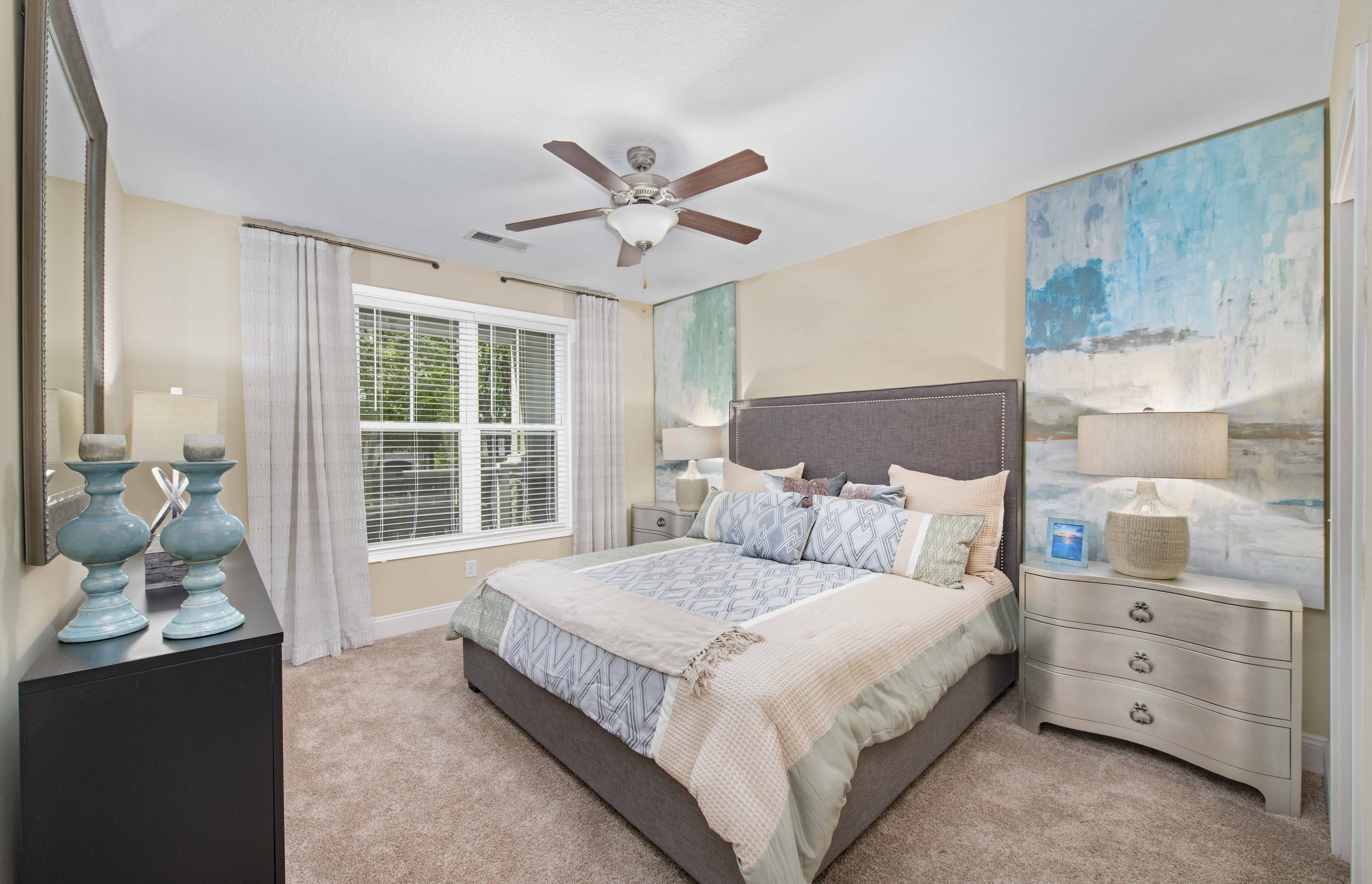 a bedroom with a bed and a ceiling fan