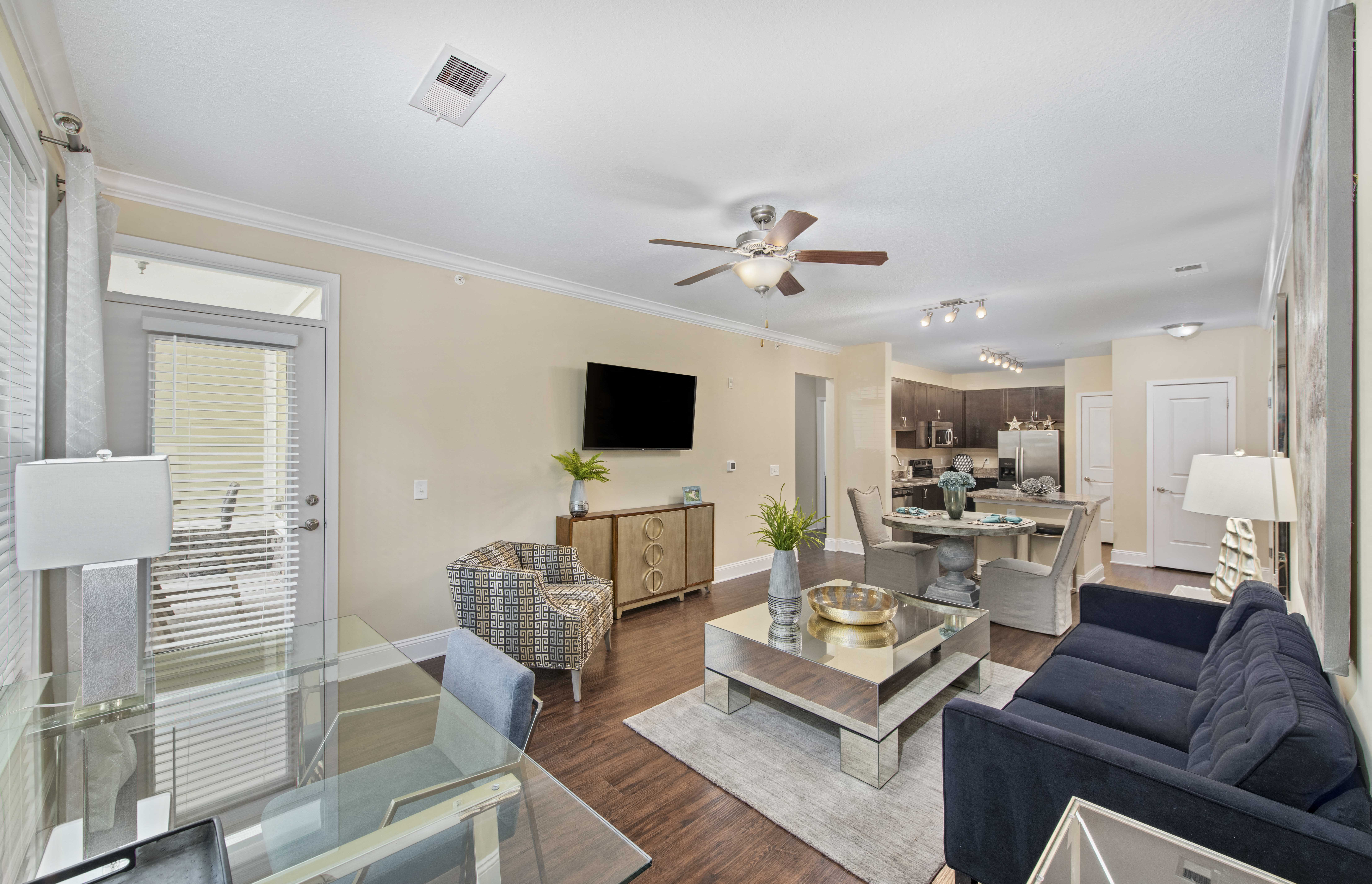 a living room with a ceiling fan and a glass table