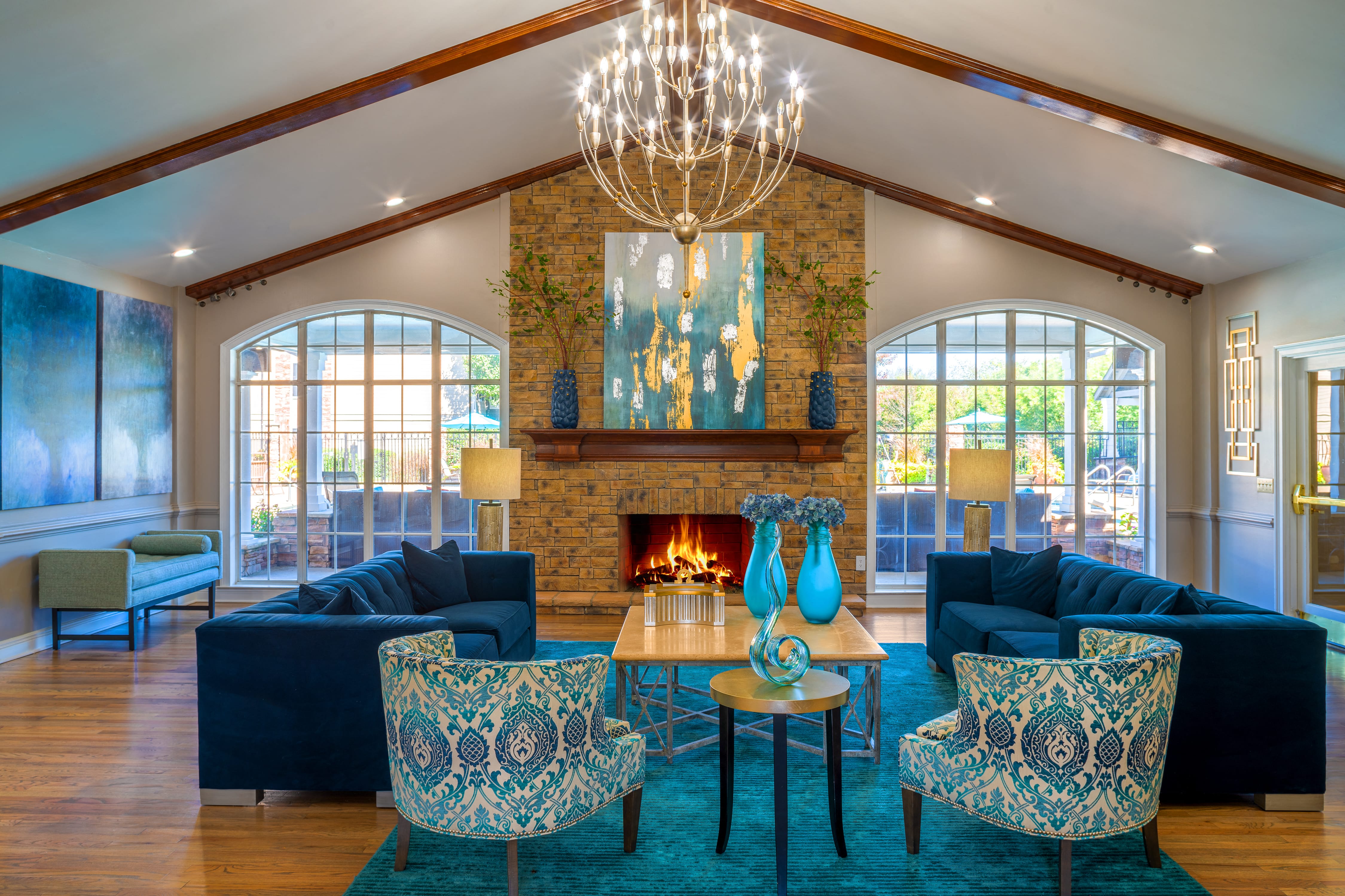 a living room with blue couches and chairs and a fireplace