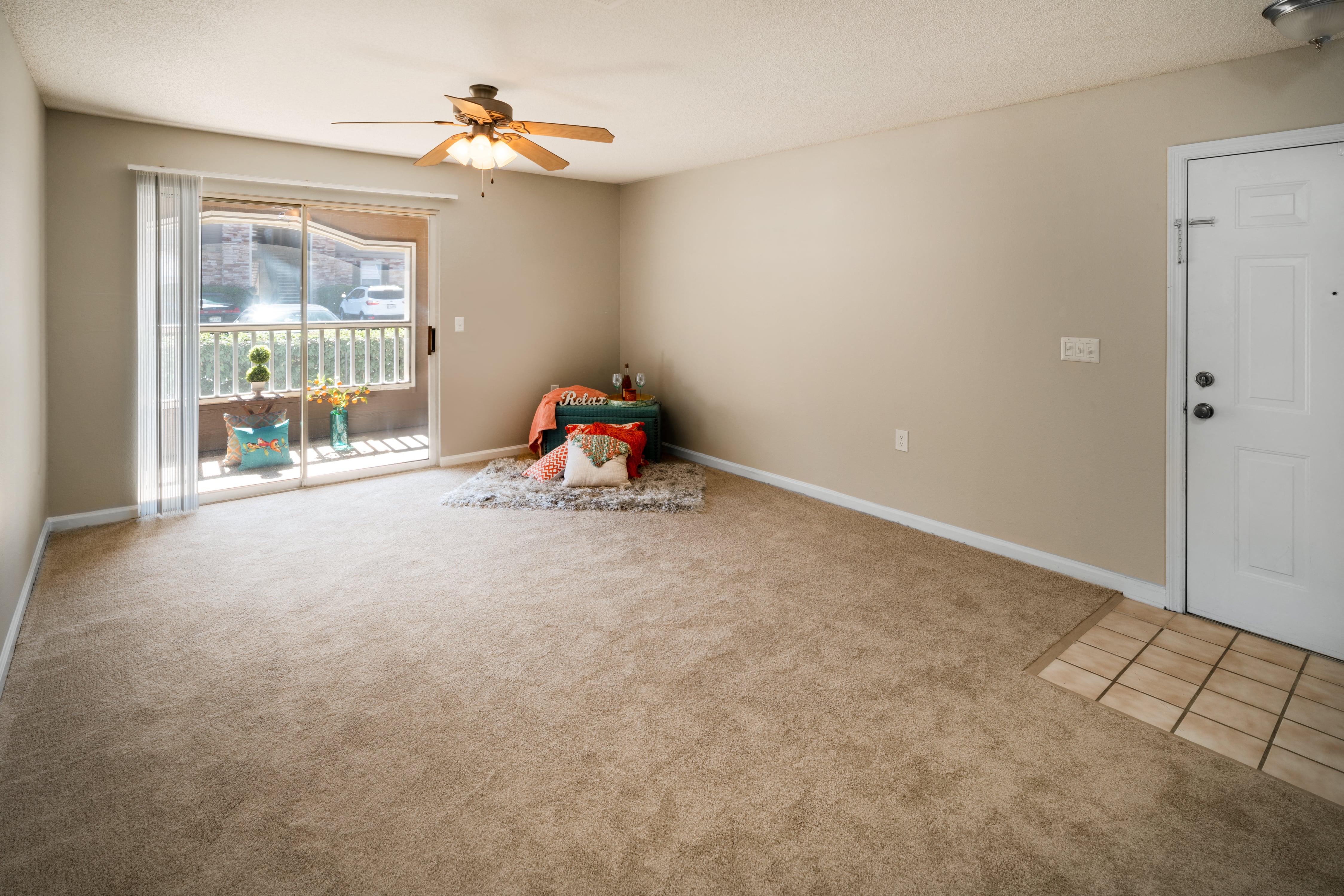 an empty living room with a ceiling fan and a window
