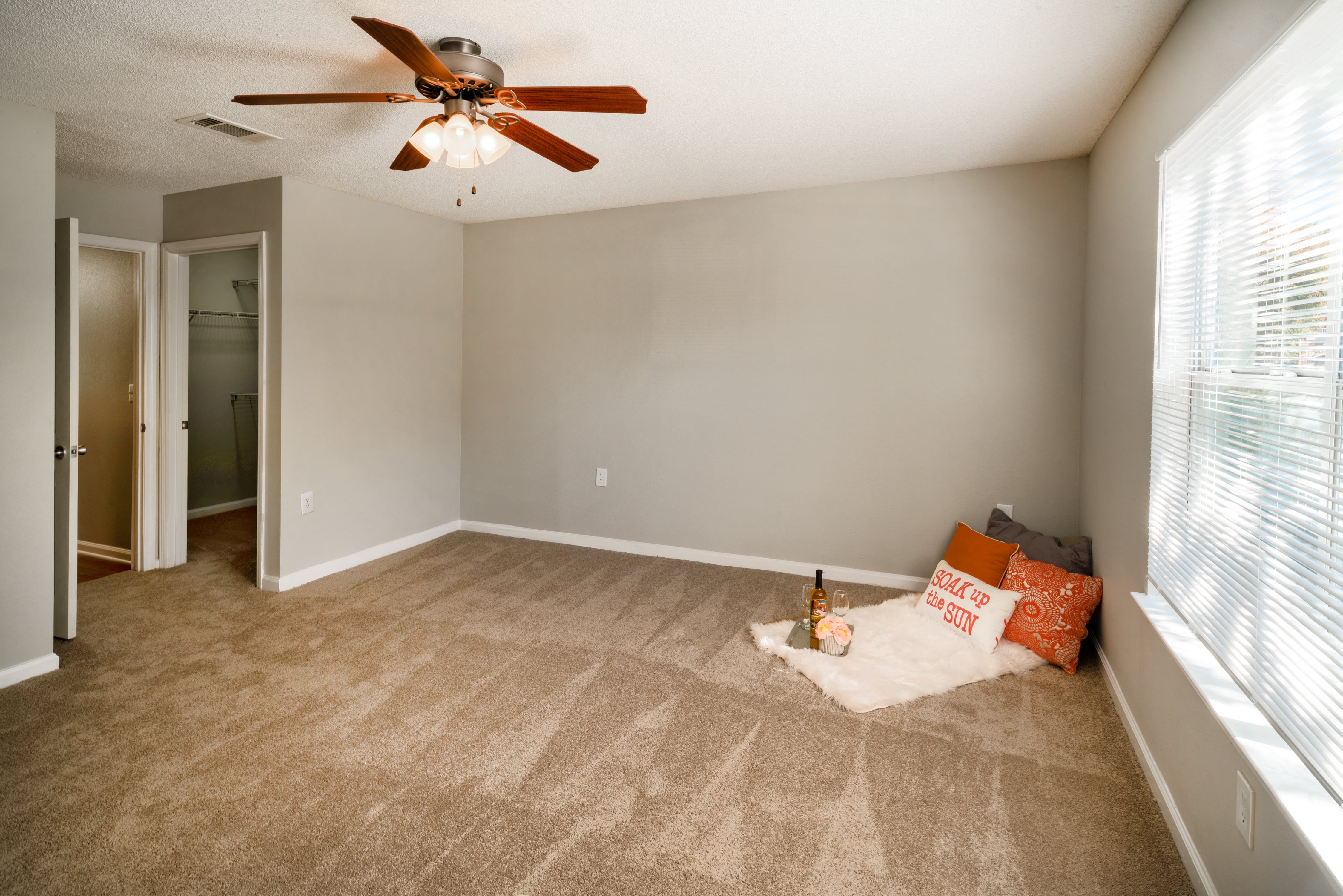 an empty living room with a ceiling fan and a couch