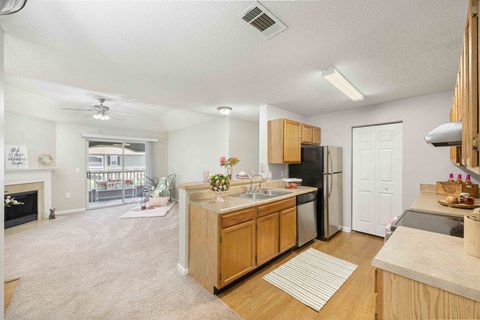 A kitchen with wooden cabinets and a black refrigerator.