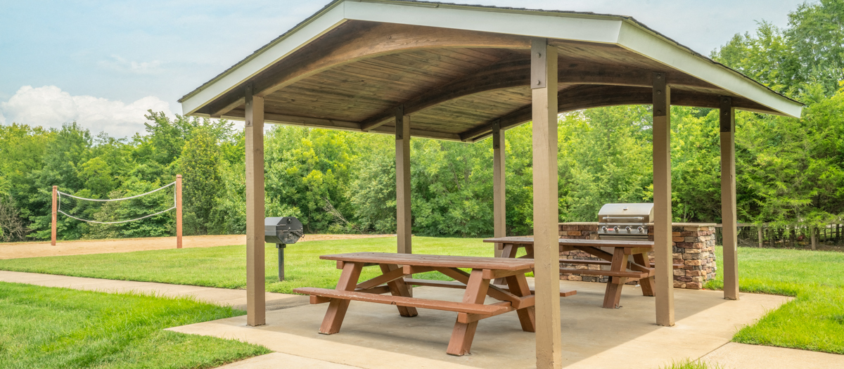 a picnic table with a grill in a park