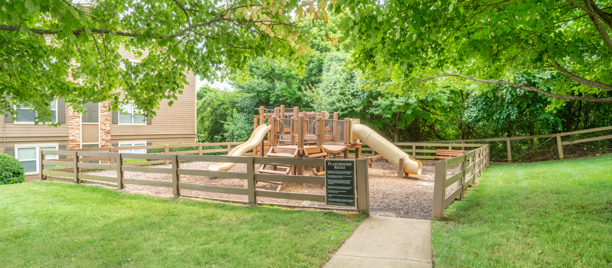 a playground in the backyard of a home with a wooden fence