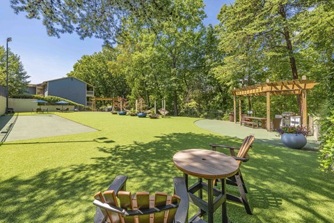 A backyard with a wooden table and chairs.