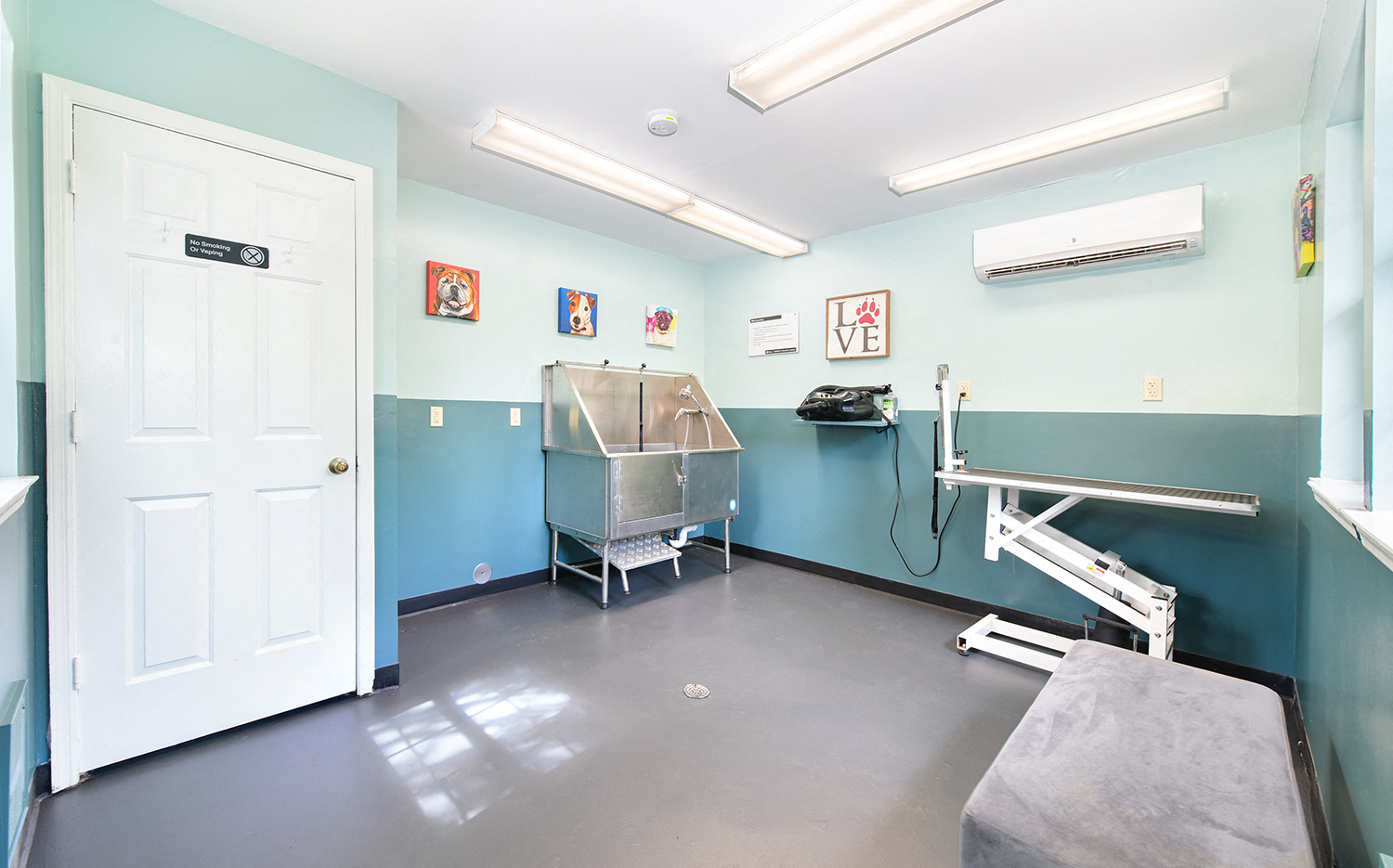 a hospital room with a sink and a cart in the corner