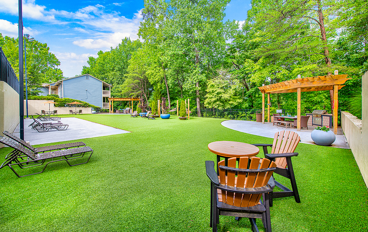 a backyard with lawn chairs and a patio with a gazebo
