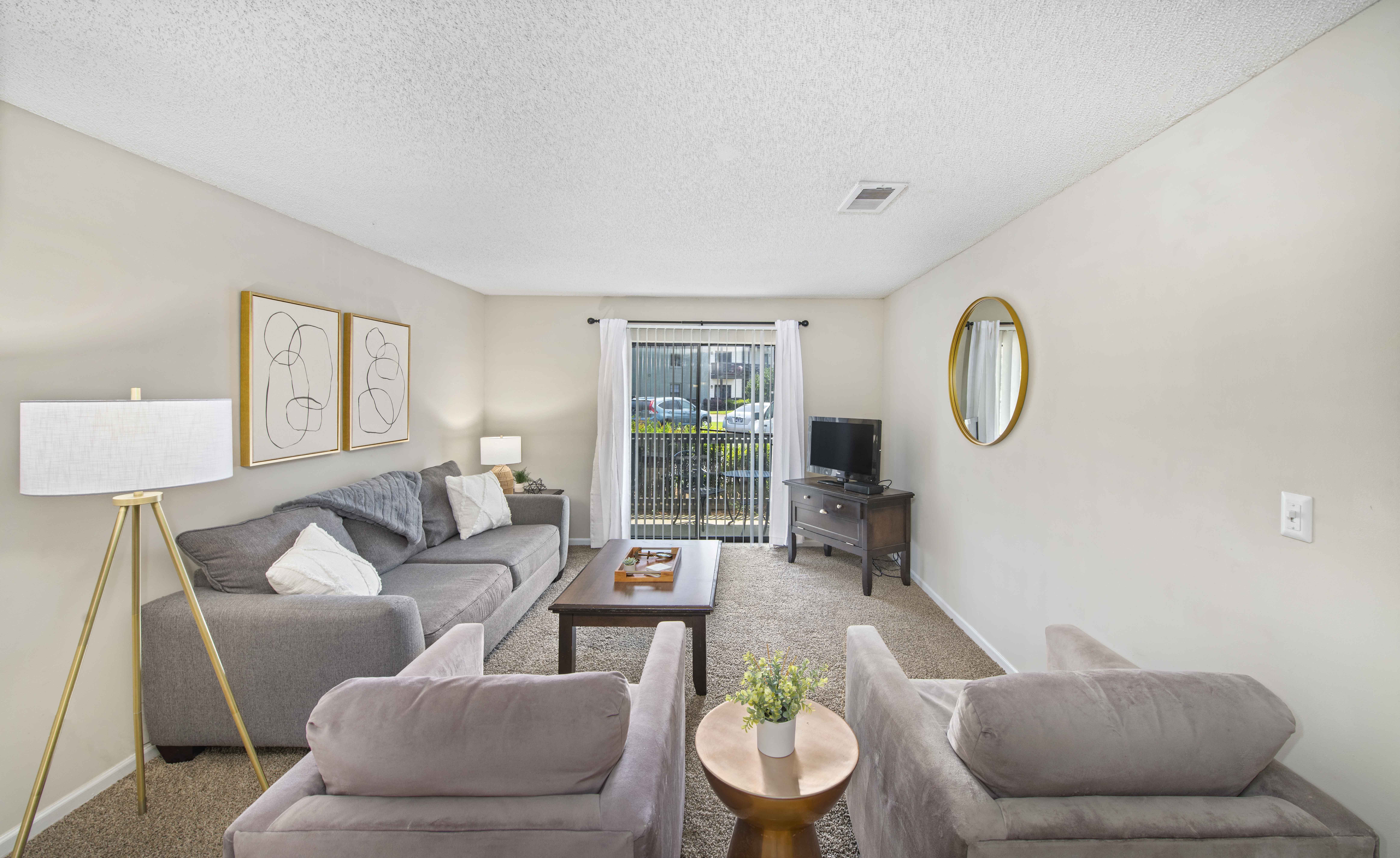 a living room with couches and chairs and a sliding glass door