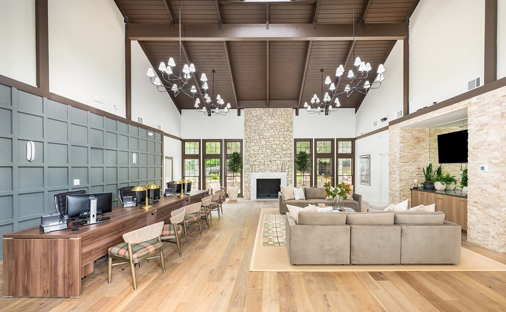 A modern living room with a stone fireplace and wooden furniture.