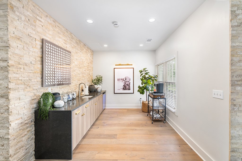 A kitchen with a black countertop and a brick wall.