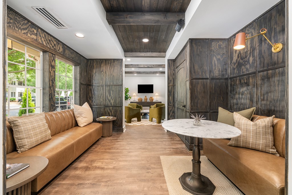 A living room with a brown couch and a white table.