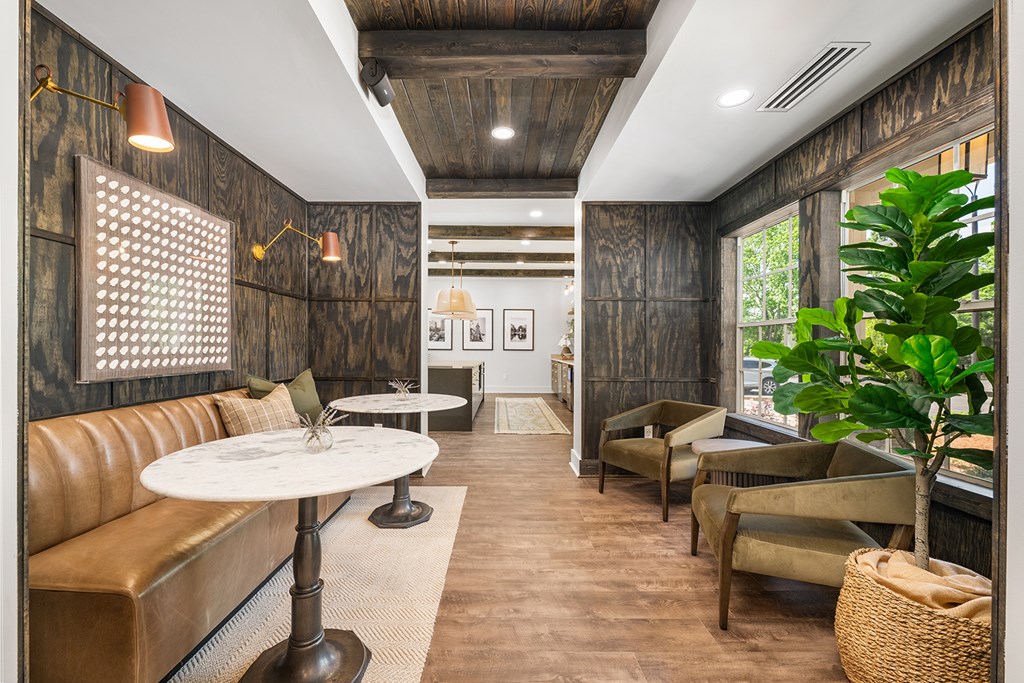 A room with a brown leather couch and a white table.