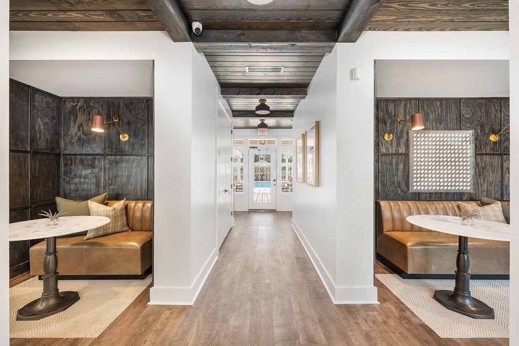 A long hallway with a table and chairs on either side.
