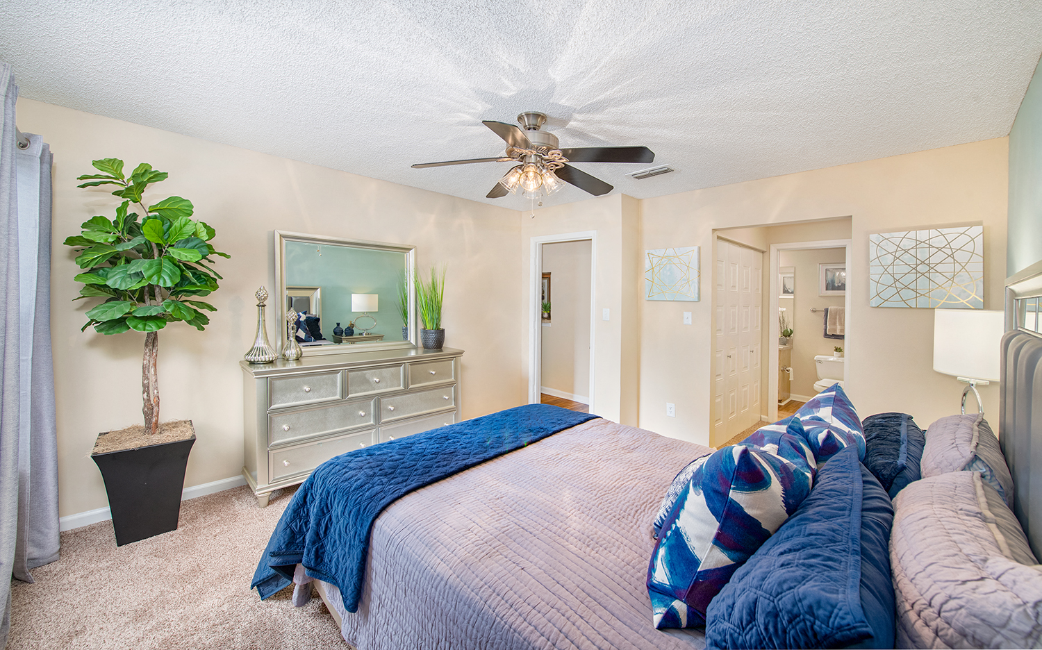 a bedroom with a large bed and a ceiling fan