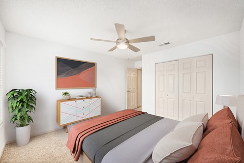A bedroom with a bed, dresser, and ceiling fan.