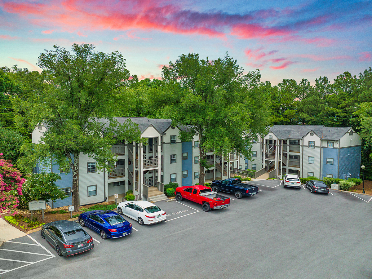 an aerial view of an apartment complex with cars parked in a parking lot