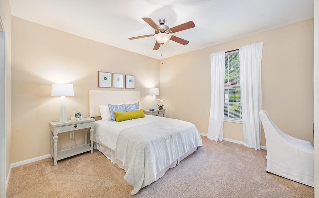 a bedroom with a large bed and a ceiling fan