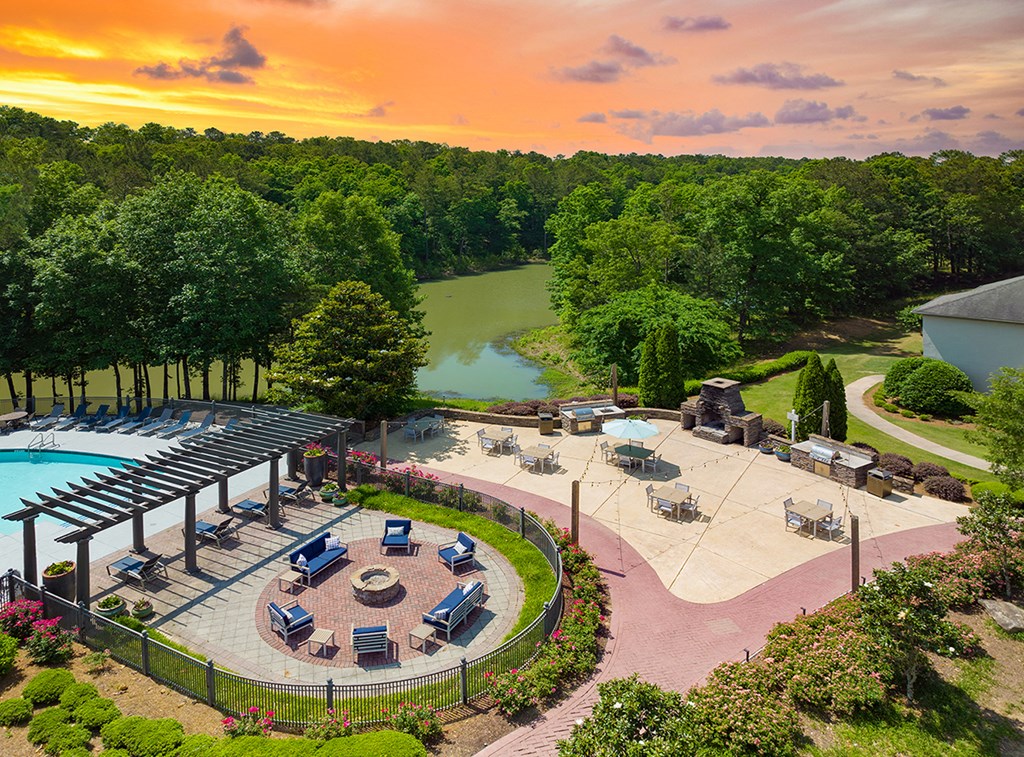 an aerial view of a swimming pool and a poolside patio with umbrellas