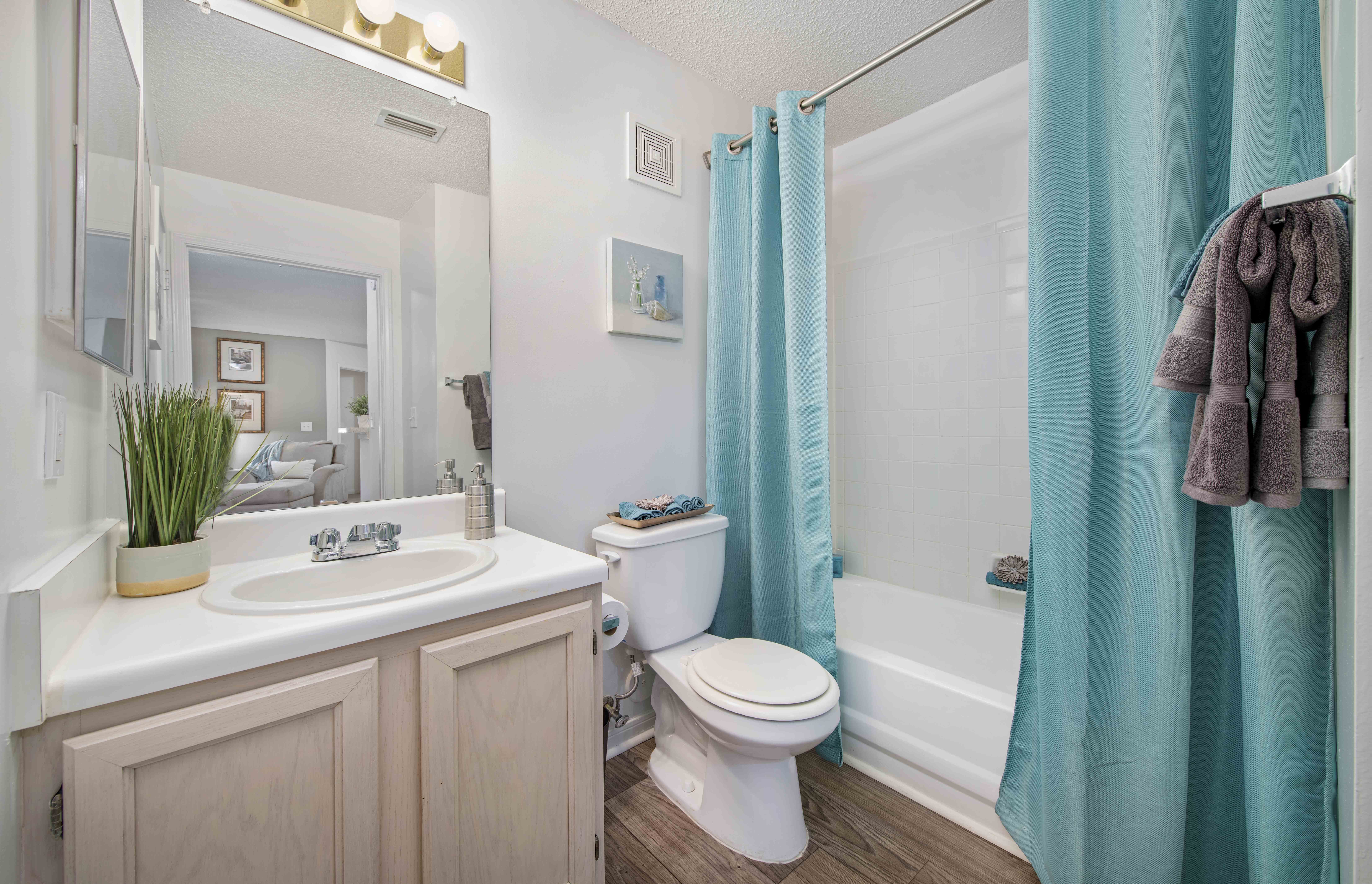 a bathroom with a blue shower curtain and a toilet and a sink