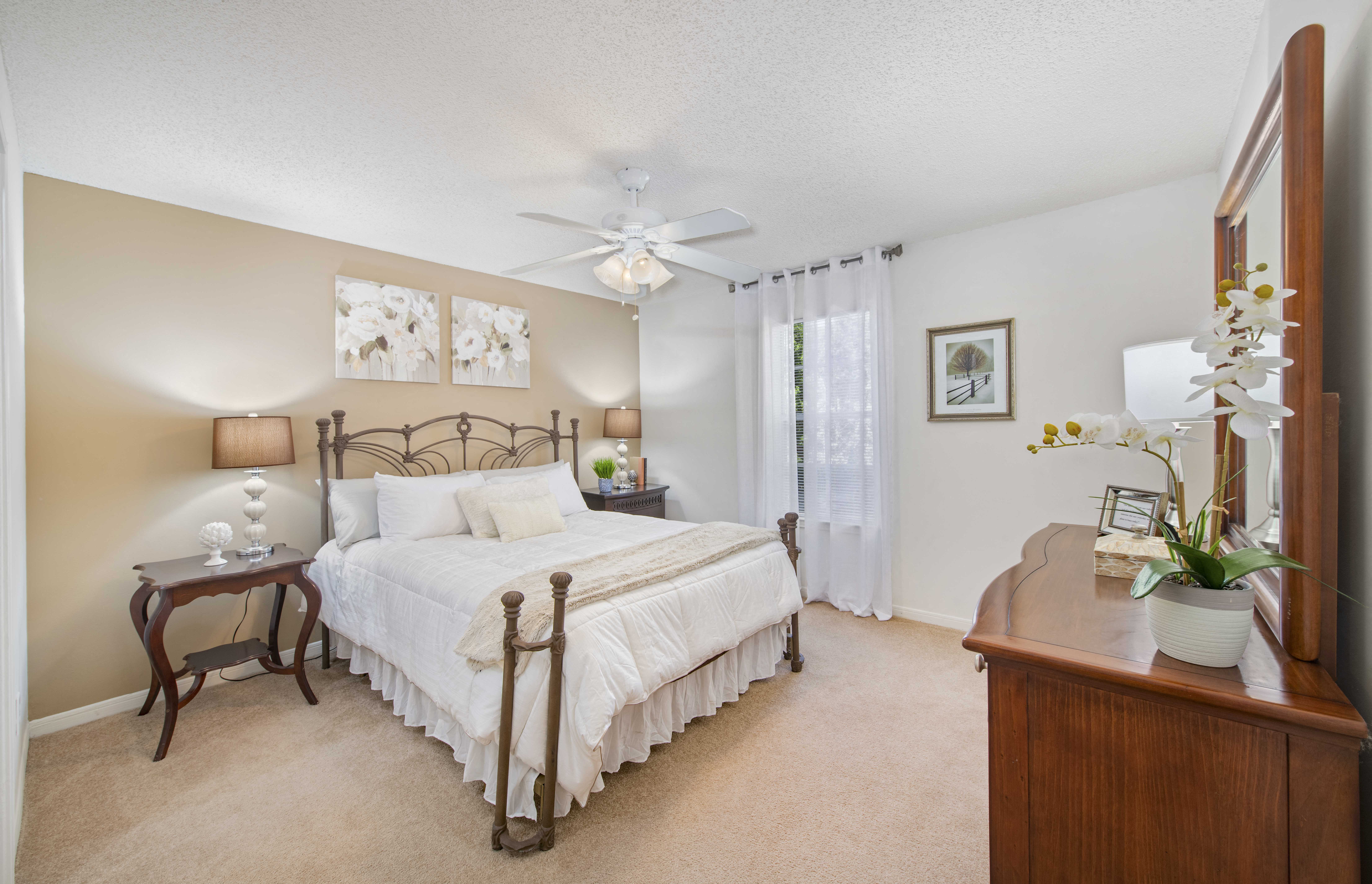 a bedroom with a bed and a ceiling fan