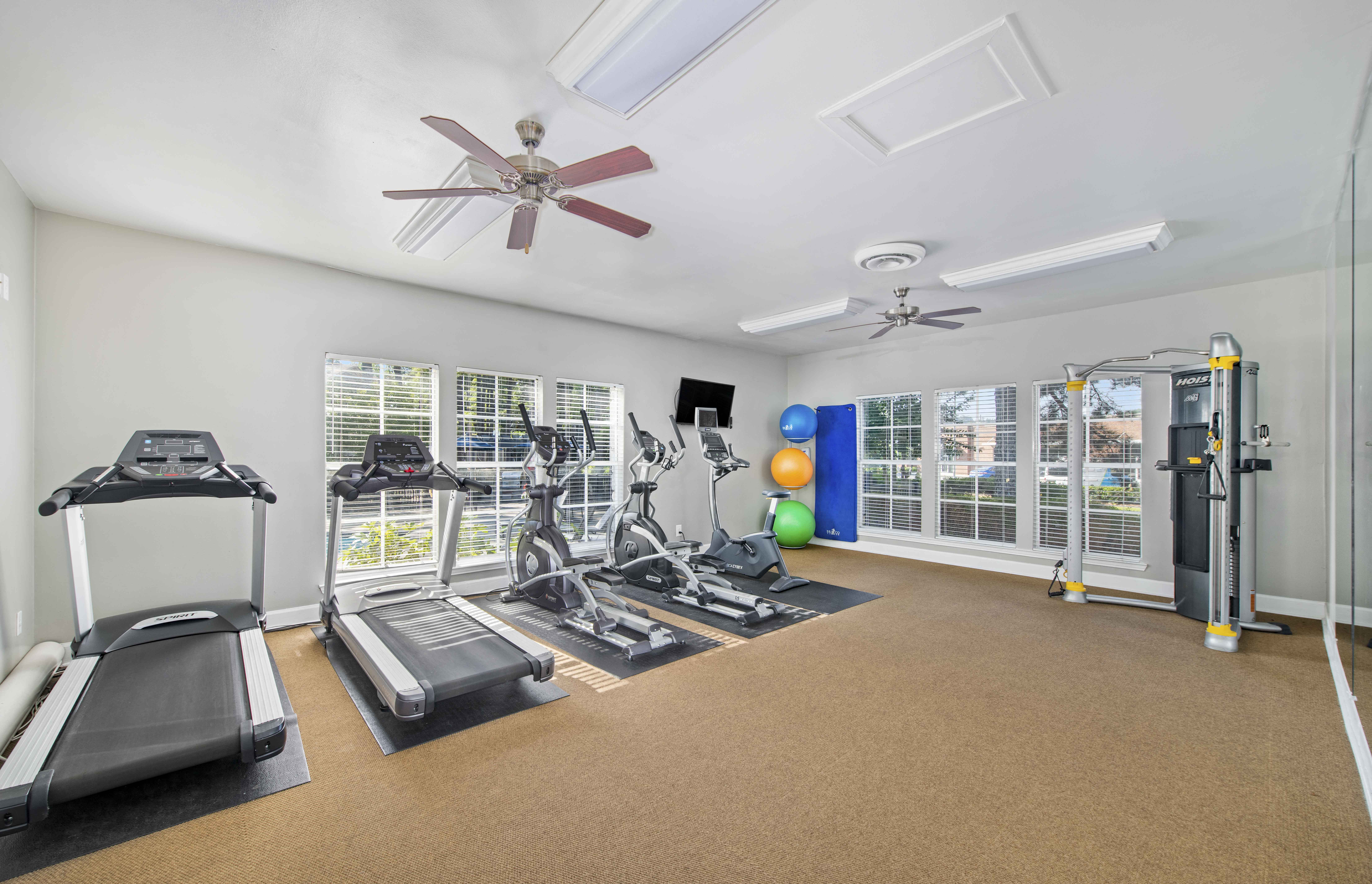 a gym with exercise machines and a ceiling fan