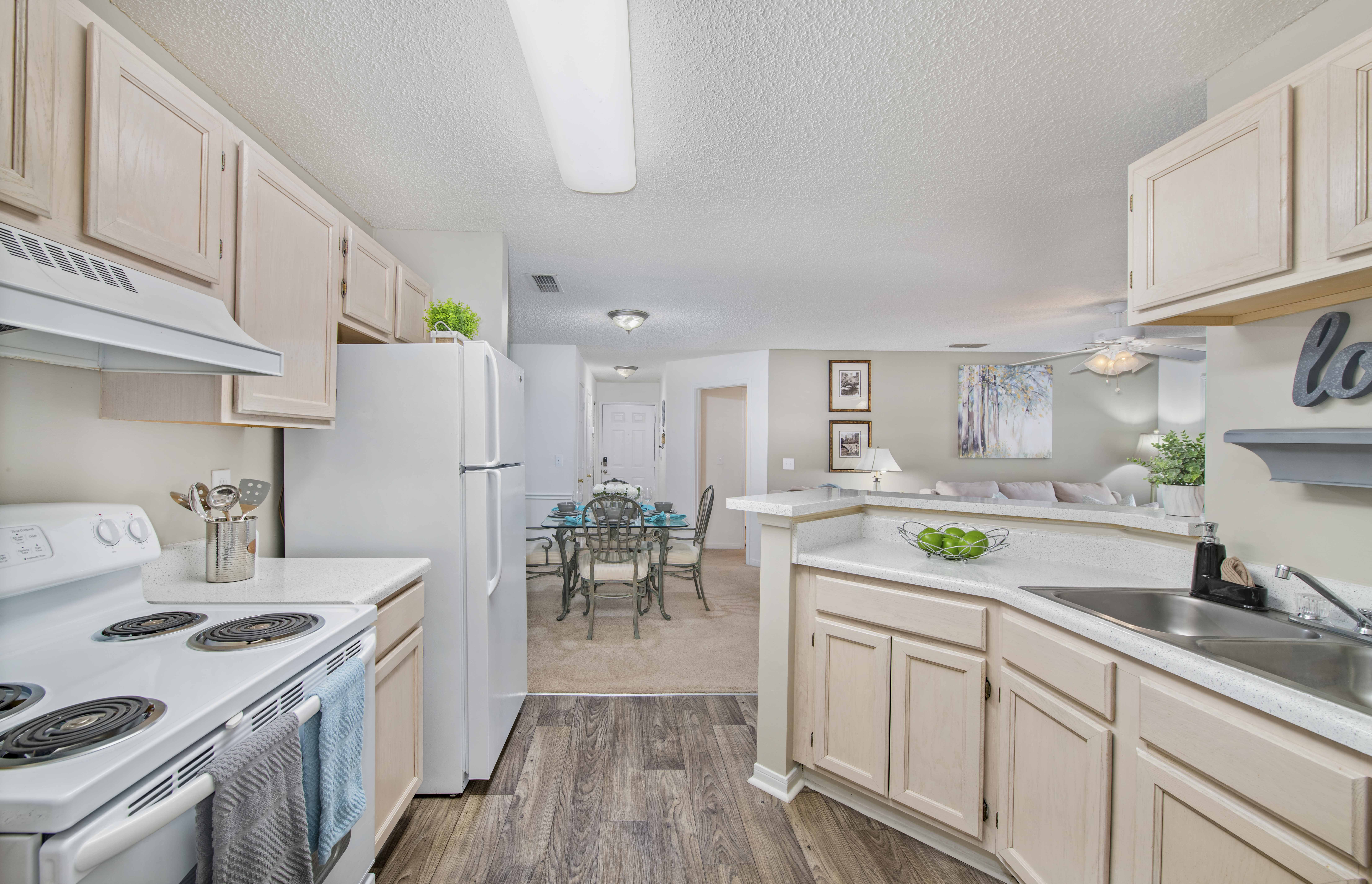 a kitchen with white appliances and wooden cabinets
