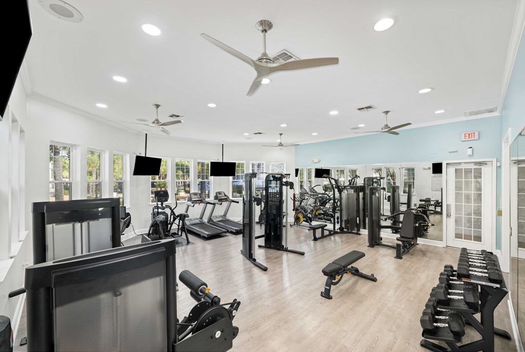 A gym with a variety of equipment including treadmills, weights, and exercise machines.