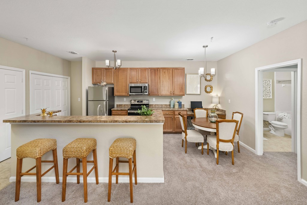 A kitchen with a bar area and a dining table.