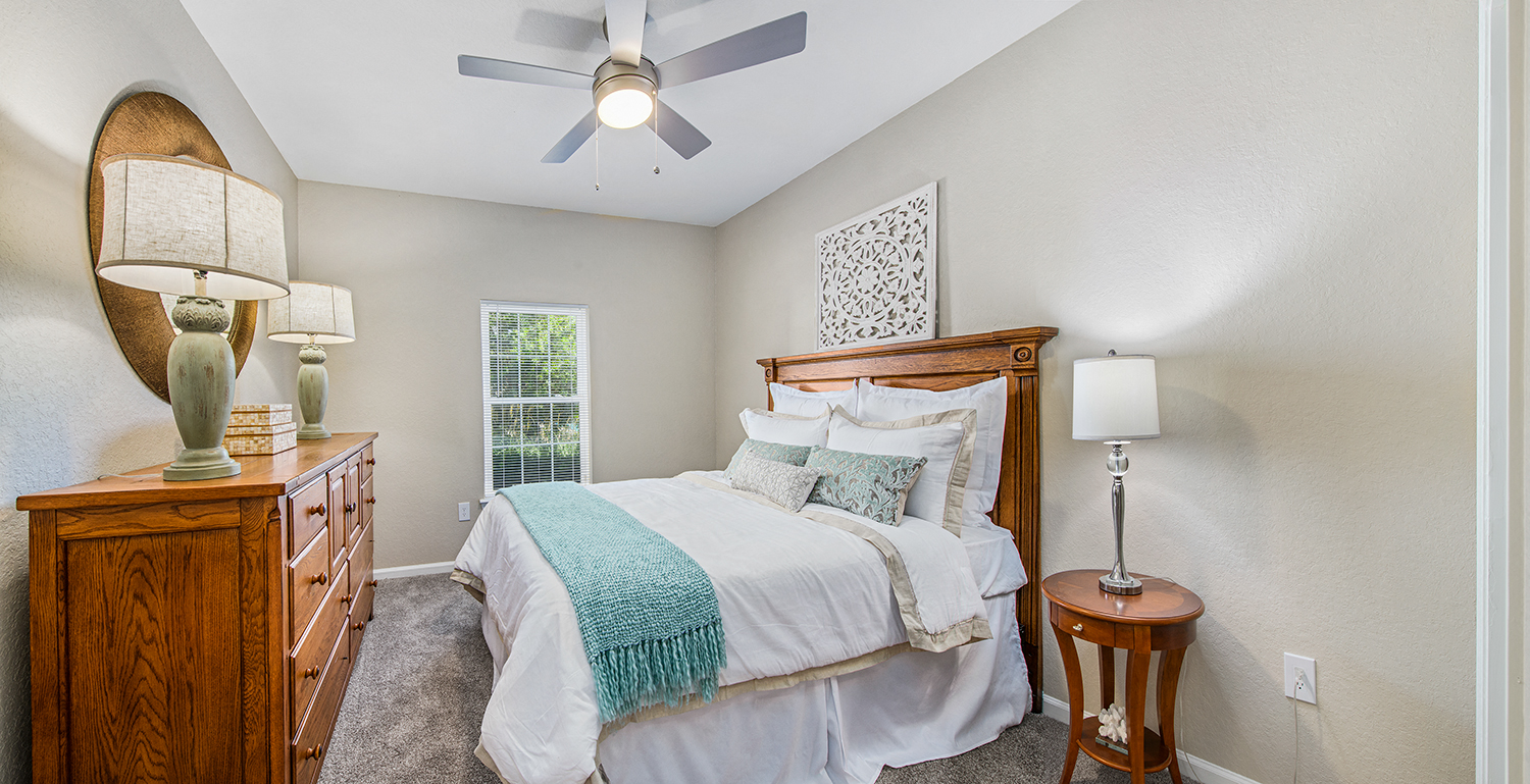 a bedroom with a large bed and a ceiling fan