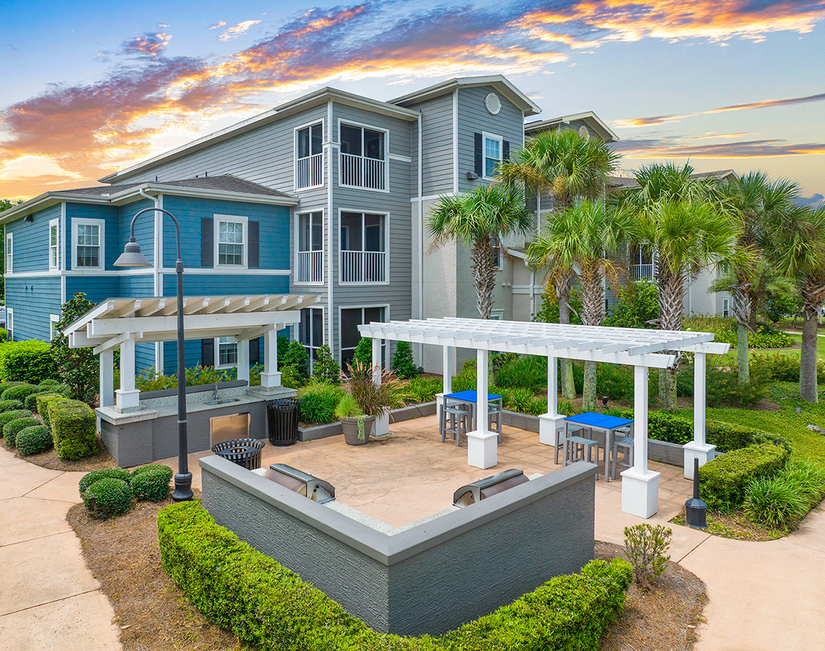 a large blue house with a patio with palm trees