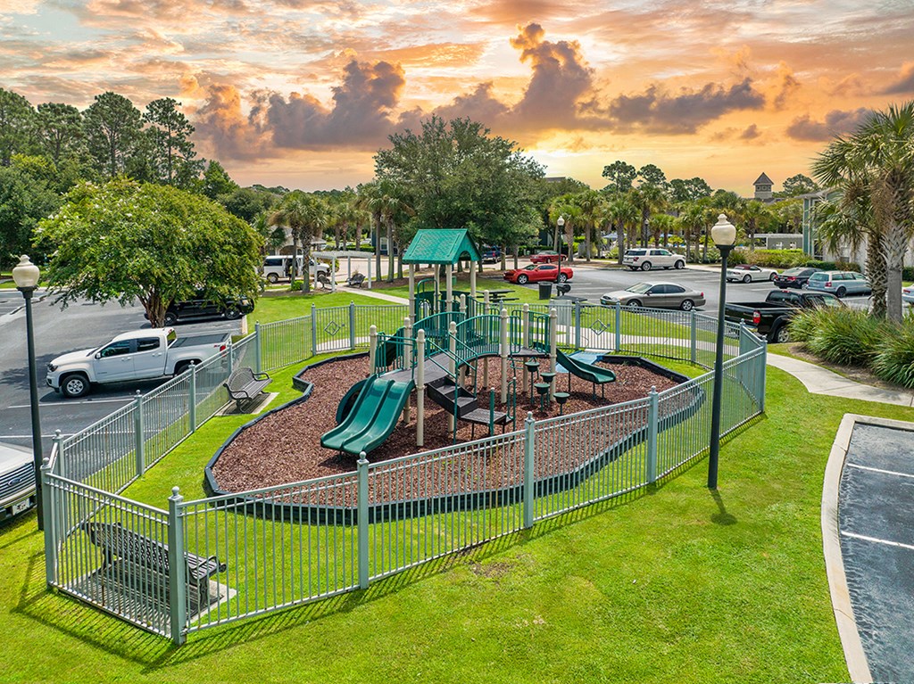 a playground in a park next to a parking lot