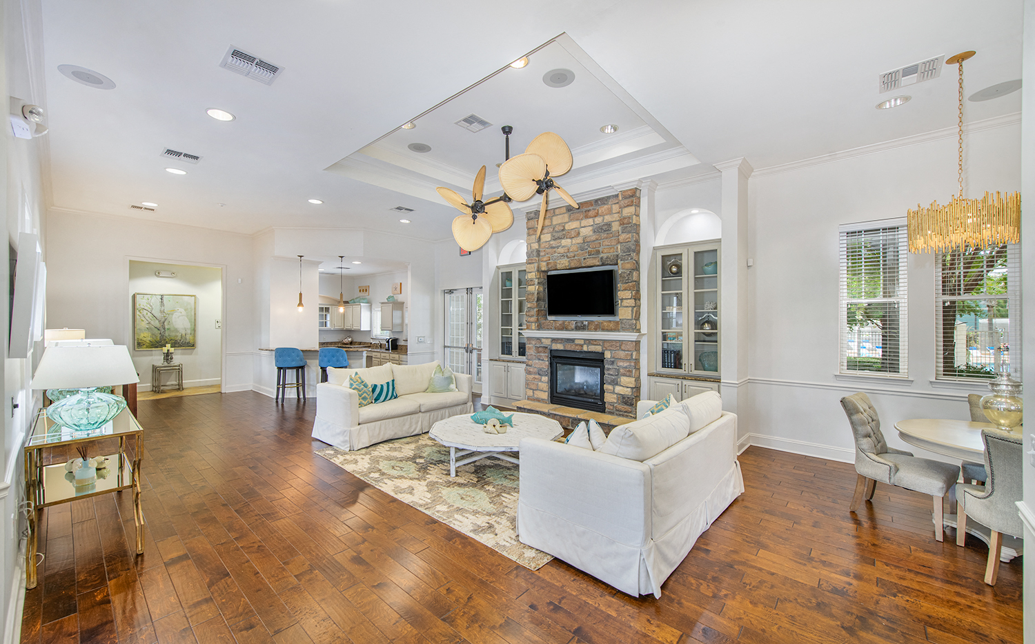 a living room with white furniture and a fireplace