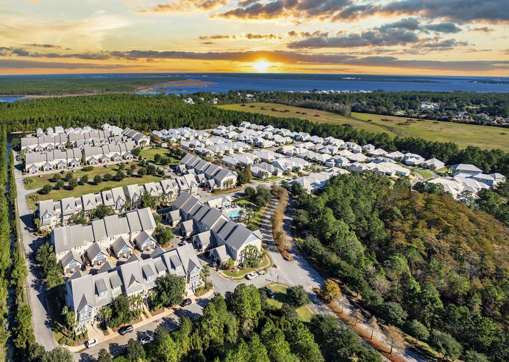 A sunset view of a residential area with houses and trees.