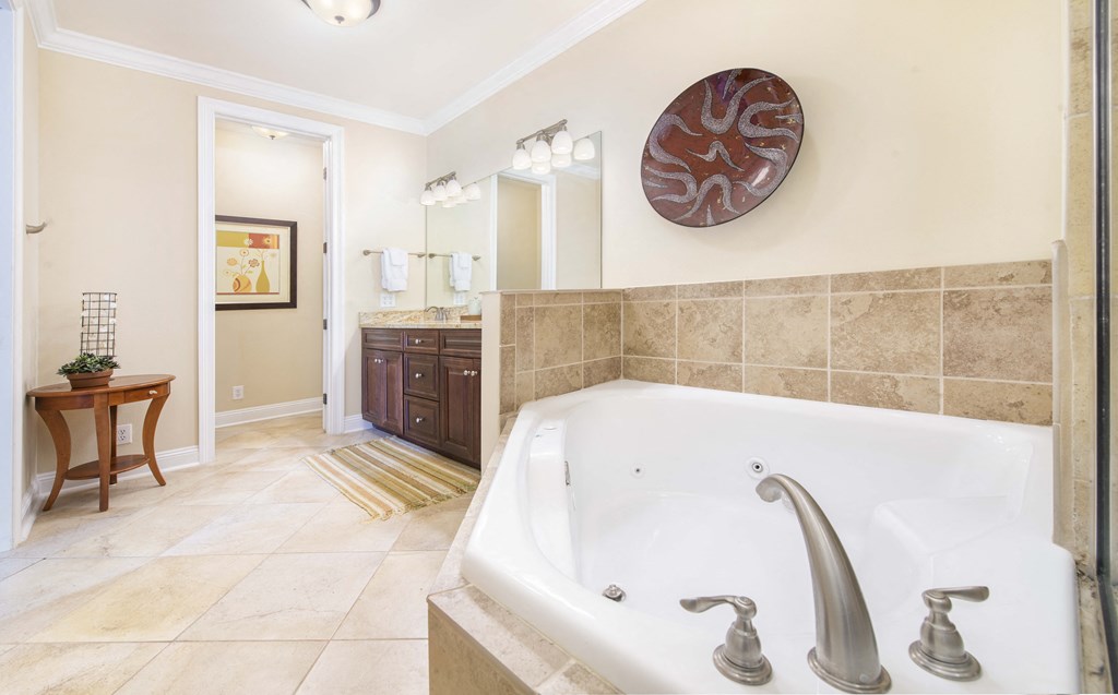 A bathroom with a tub and a mirror.